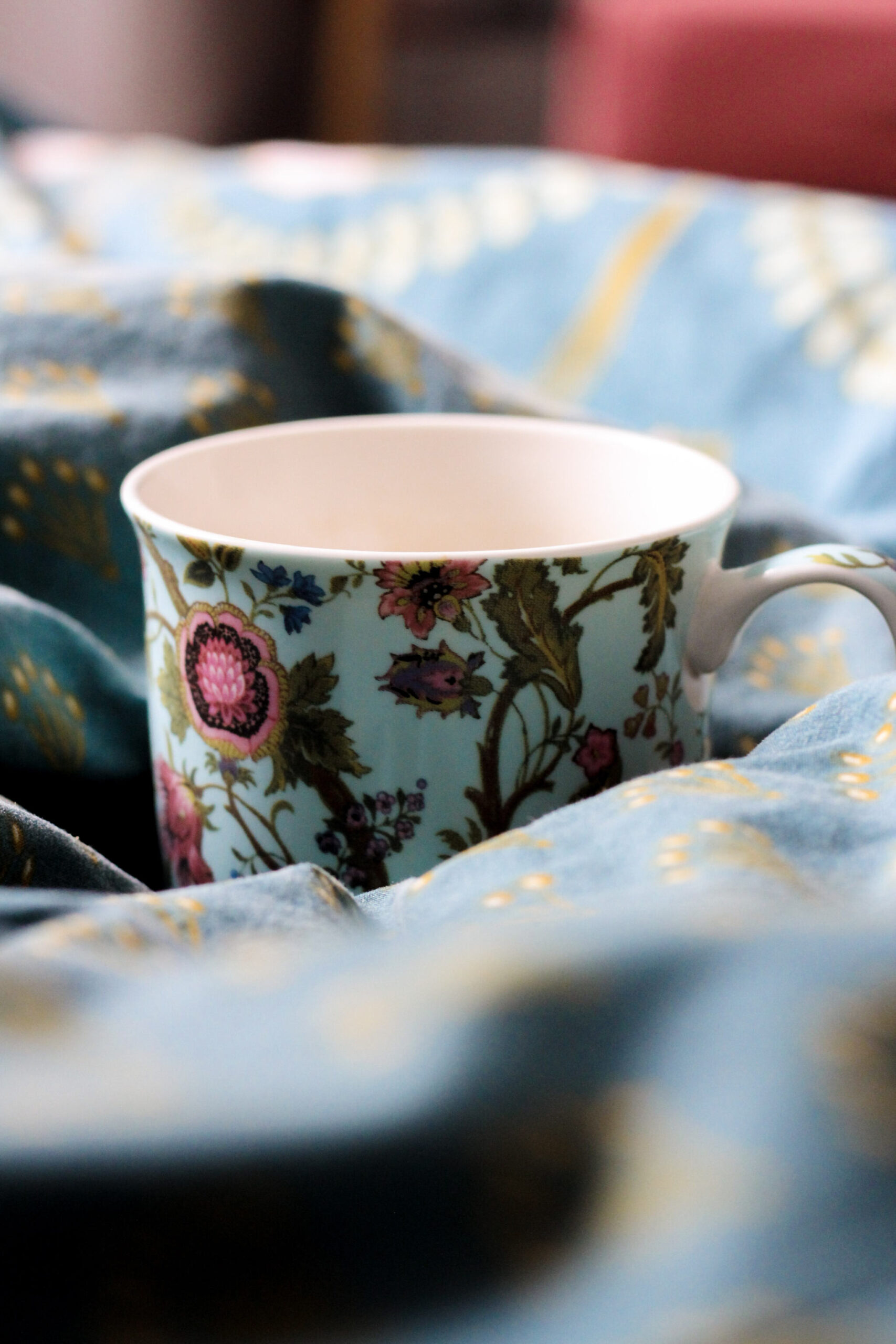 Cup of coffee on bedsheets