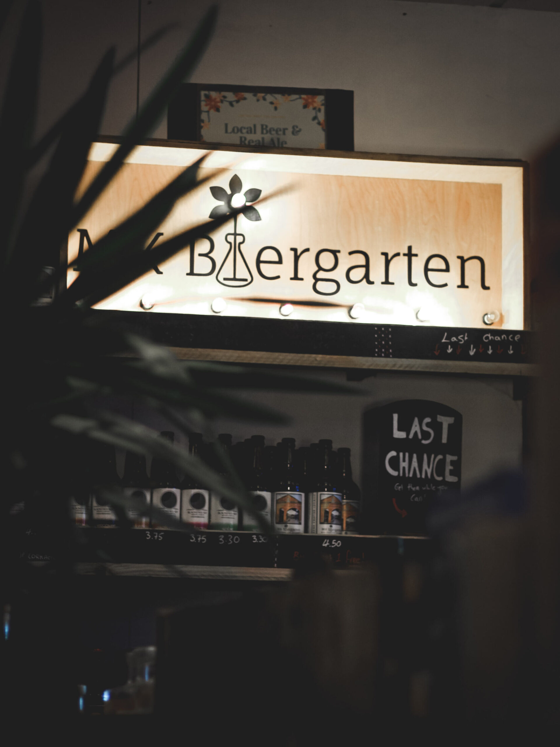 The sign for MK Biergarten peeks through some indoor plants
